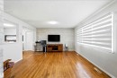 Hardwood-finish flooring throughout, accent wall with light-toned stacked stone, and large window with layered shades - 13604 90A Street Nw, Edmonton, AB  - Indoor 