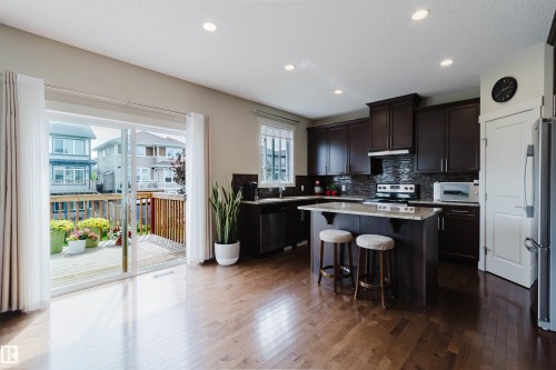Open concept living area with wood-finish flooring - 3843 Agar Green Sw, Edmonton, AB - Indoor Photo Showing Kitchen With Upgraded Kitchen