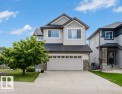 Stone accent siding, light-toned horizontal siding, attached garage, concrete driveway, and a pitched roof - 3843 Agar Green Sw, Edmonton, AB  - Outdoor With Facade 