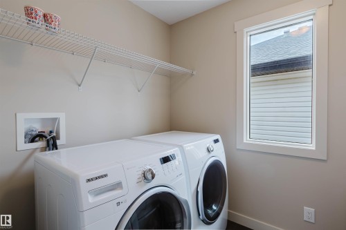 Utility area featuring a window with white trim, a built-in wire shelf, and an appliance hookup - 3843 Agar Green Sw, Edmonton, AB - Indoor Photo Showing Laundry Room