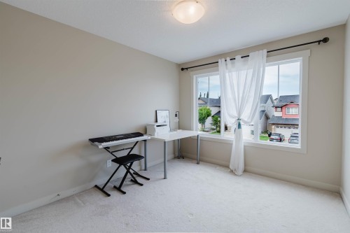 Neutral-toned walls, light-colored carpet, large windows, and a ceiling-mounted light fixture - 3843 Agar Green Sw, Edmonton, AB - Indoor Photo Showing Office