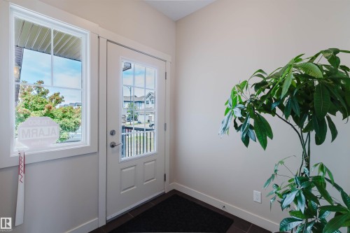 Entryway featuring a white paneled door with glass inserts, a single-hung window, and dark flooring - 3843 Agar Green Sw, Edmonton, AB - Indoor Photo Showing Other Room
