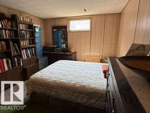 Room featuring wood-paneled walls and a drop ceiling - 13508 64 Street Nw, Edmonton, AB - Indoor Photo Showing Bedroom