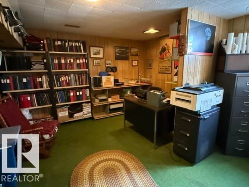 Wood-paneled room with built-in shelving, recessed lighting, and green carpeting - 13508 64 Street Nw, Edmonton, AB - Indoor Photo Showing Office