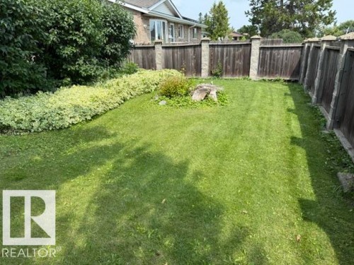 Expansive grass lawn bordered by mature landscaping - 13508 64 Street Nw, Edmonton, AB - Outdoor