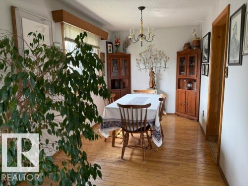 Dining area featuring wood-finish flooring, white walls, and a multi-arm chandelier - 13508 64 Street Nw, Edmonton, AB - Indoor Photo Showing Dining Room