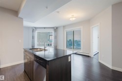 Kitchen island with dark cabinetry, integrated stainless steel dishwasher, and undermount sink - 