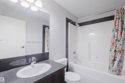 Integrated vanity with an undermount sink, a chrome faucet, and a large wall-mounted mirror - 