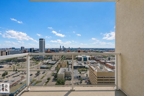 Balcony with clear glass railing, white metal handrail, and high-rise cityscape - #2207 10226 104 St Nw, Edmonton, AB - Outdoor With Balcony With View