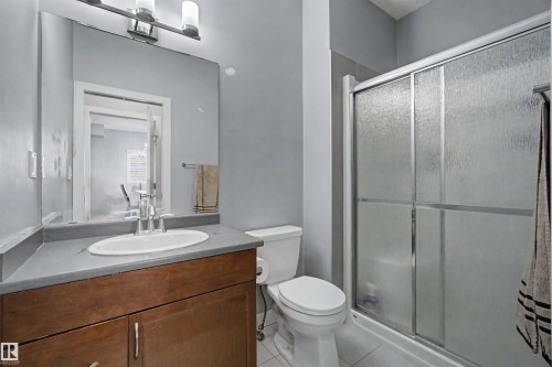 Wood-finish vanity with an integrated sink and chrome faucet - 1602 Chapman Way Sw, Edmonton, AB - Indoor Photo Showing Bathroom
