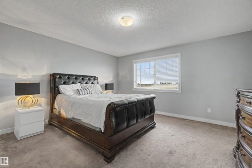 Broadloom carpet, neutral wall paint, overhead lighting, and a window with blinds - 1602 Chapman Way Sw, Edmonton, AB - Indoor Photo Showing Bedroom