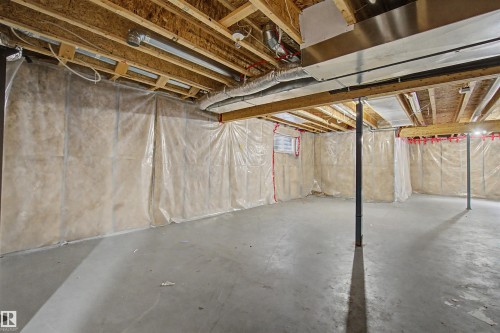 Expansive concrete flooring with exposed wood joists and structural beams - 1602 Chapman Way Sw, Edmonton, AB - Indoor Photo Showing Basement