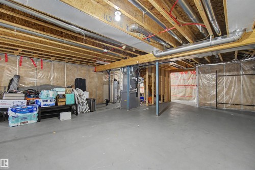 Unfinished basement with exposed ceiling joists, visible HVAC ductwork, and structural wood framing - 1602 Chapman Way Sw, Edmonton, AB - Indoor Photo Showing Basement