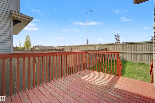 Expansive deck with wood railing, featuring a large backyard and privacy fencing - 1602 Chapman Way Sw, Edmonton, AB - Outdoor With Deck Patio Veranda With Exterior