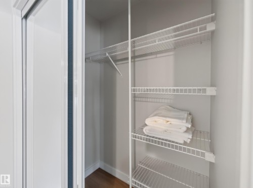 Sliding closet doors, wire shelving, hanging rod. - #314 237 Youville Dr E Nw, Edmonton, AB - Indoor With Storage