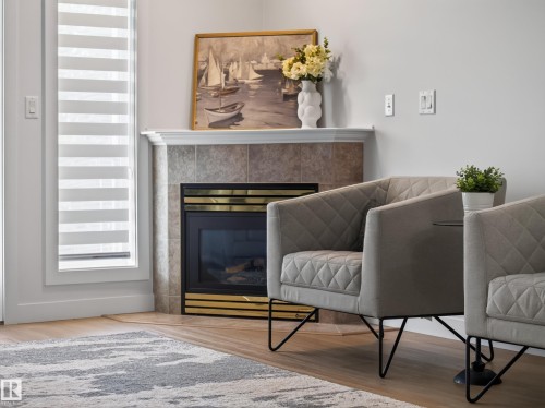 Corner fireplace with a tile surround and mantel - #314 237 Youville Dr E Nw, Edmonton, AB - Indoor Photo Showing Other Room With Fireplace