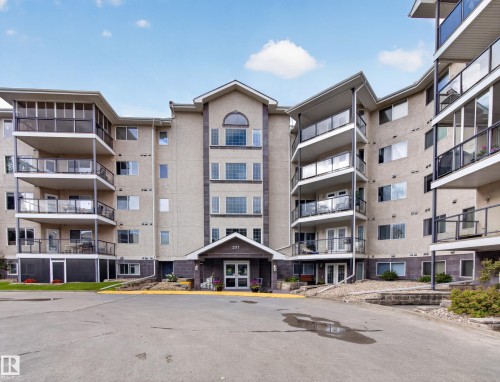 Multi-story residential building featuring a stucco exterior with stone accents - #314 237 Youville Dr E Nw, Edmonton, AB - Outdoor With Balcony With Facade