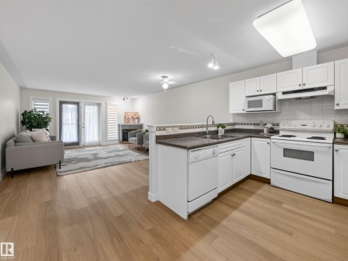 Open-concept living space featuring a kitchen with white cabinetry. - #314 237 Youville Dr E Nw, Edmonton, AB - Indoor Photo Showing Kitchen