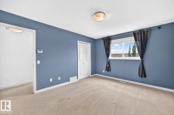 Carpeted flooring with a large window, a closet with bi-fold doors, and a flush mount ceiling light fixture - 