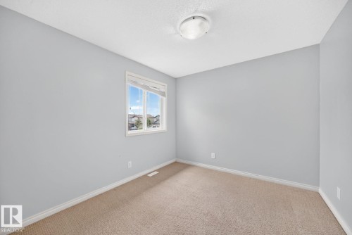 Neutral-toned carpeting paired with light grey walls - 217 Silverstone Crescent, Stony Plain, AB - Indoor Photo Showing Other Room