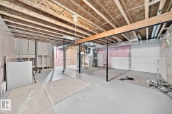 Unfinished basement with exposed wood joists, structural support beams, and partially insulated walls - 