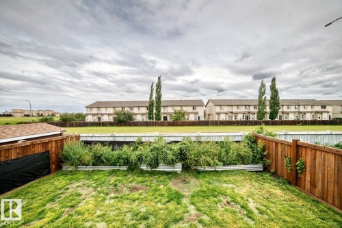 Expansive backyard featuring a wood-panel fence, raised garden beds, and a storage shed with a shingled roof - 217 Silverstone Crescent, Stony Plain, AB - Outdoor