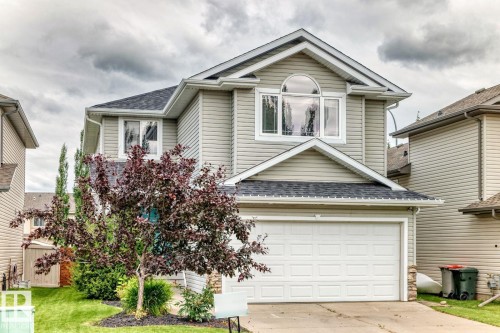 Two-story residence featuring light-colored siding, a prominent arched window, and a two-car garage - 217 Silverstone Crescent, Stony Plain, AB - Outdoor With Exterior