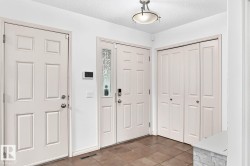 Tiled flooring, multiple paneled doors, decorative glass sidelight, and a flush-mount ceiling light fixture - 