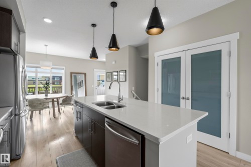 Kitchen featuring a large central island with a double sink, stainless steel appliances, dark wood cabinetry, and pendant lighting - 45 Joyal Way, St. Albert, AB - Indoor Photo Showing Kitchen With Double Sink With Upgraded Kitchen