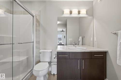 Spacious vanity with a white undermount sink, countertop, and dark wood-finish cabinetry - 45 Joyal Way, St. Albert, AB - Indoor Photo Showing Bathroom
