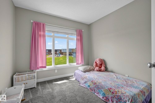 Light gray wall paint, carpeting, large window with white trim, and a white interior door - 45 Joyal Way, St. Albert, AB - Indoor Photo Showing Bedroom