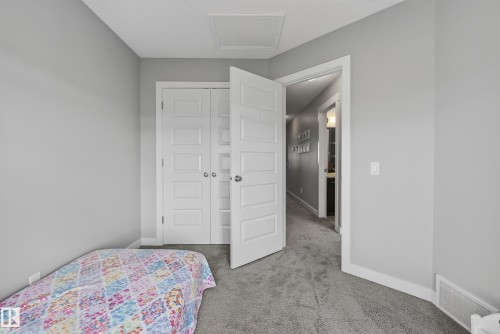 Light gray wall paint, gray carpet flooring, white paneled doors, white trim, and a white ceiling access panel - 45 Joyal Way, St. Albert, AB - Indoor Photo Showing Bedroom