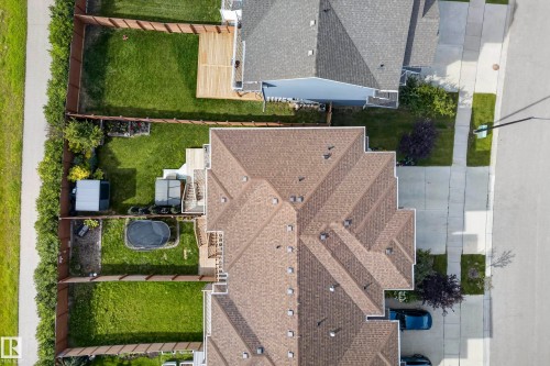 Asphalt shingle roof, paved driveway, concrete sidewalk, fenced backyard, and a wooden deck - 45 Joyal Way, St. Albert, AB - Outdoor