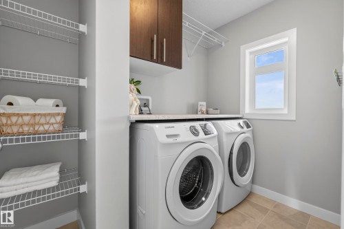 Laundry area featuring wire shelving, built-in cabinetry, a countertop, and a window - 45 Joyal Way, St. Albert, AB - Indoor Photo Showing Laundry Room