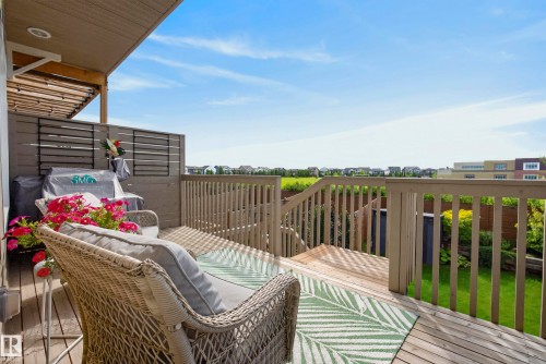 Elevated composite deck with horizontal wood-finish railings and slatted decking, anchored by a modern covered structure with wood-finish ceiling - 45 Joyal Way, St. Albert, AB - Outdoor With Deck Patio Veranda With Exterior