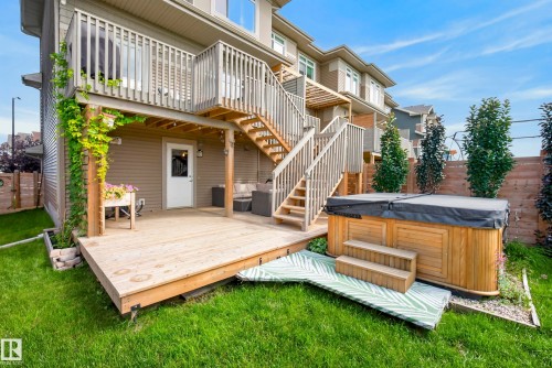 Tiered wood decking with a built-in hot tub, privacy fencing, and mature landscaping - 45 Joyal Way, St. Albert, AB - Outdoor With Deck Patio Veranda With Exterior