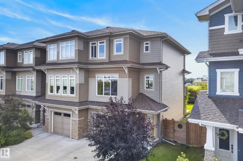 Multi-level townhome with an attached garage, featuring a stone and siding exterior - 45 Joyal Way, St. Albert, AB - Outdoor With Facade