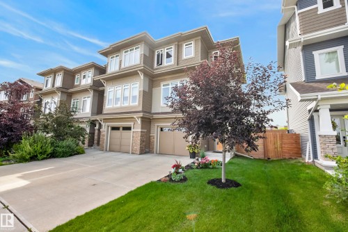 Three-story structure featuring a combination of siding and stone veneer, multiple windows, and a two-car garage with individual doors - 45 Joyal Way, St. Albert, AB - Outdoor With Facade