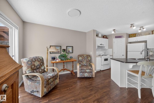 Open-concept living space with dark wood-finish flooring - #7 155 Crocus Cr, Sherwood Park, AB - Indoor Photo Showing Other Room