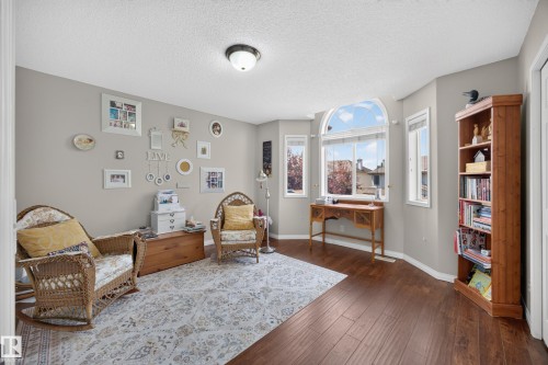 Room featuring wood-finish flooring, light gray walls, and a large arched window - #7 155 Crocus Cr, Sherwood Park, AB - Indoor