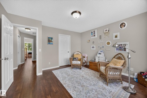 Interior room featuring dark wood-finish flooring, light neutral wall paint, white trim, and a flush-mount ceiling light - #7 155 Crocus Cr, Sherwood Park, AB - Indoor