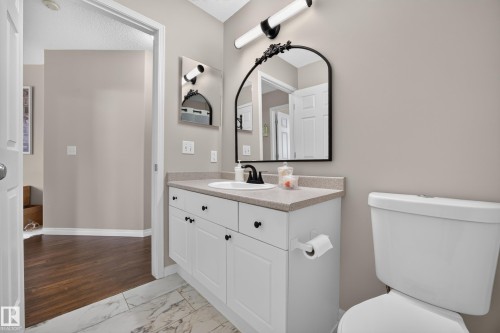 Bathroom featuring a white vanity with cabinet storage, a light-toned countertop, and a black-framed mirror - #7 155 Crocus Cr, Sherwood Park, AB - Indoor Photo Showing Bathroom