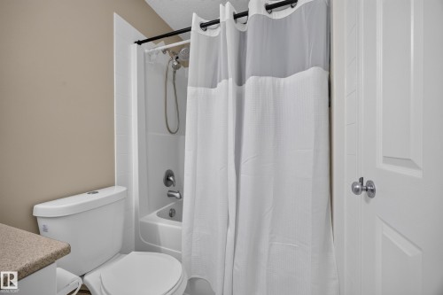 Full white shower-over-tub combination with chrome fixtures and showerhead - #7 155 Crocus Cr, Sherwood Park, AB - Indoor Photo Showing Bathroom