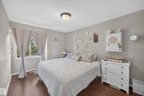 Warm wood-finish flooring complements light-toned walls - #7 155 Crocus Cr, Sherwood Park, AB - Indoor Photo Showing Bedroom