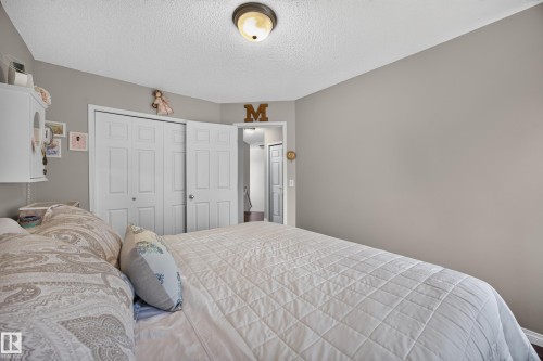 Spacious room featuring neutral painted walls, textured ceiling, and a ceiling-mounted light fixture - #7 155 Crocus Cr, Sherwood Park, AB - Indoor Photo Showing Bedroom