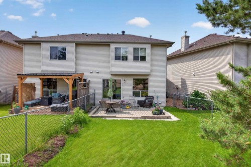 Expansive backyard featuring a manicured lawn, a chain-link fence, and a patio with a pergola - #7 155 Crocus Cr, Sherwood Park, AB - Outdoor With Exterior