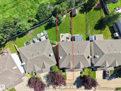 Overhead perspective showcasing a residential property with a shingled roof, a paved driveway, and a fenced backyard featuring a patio area - #7 155 Crocus Cr, Sherwood Park, AB - Outdoor With View