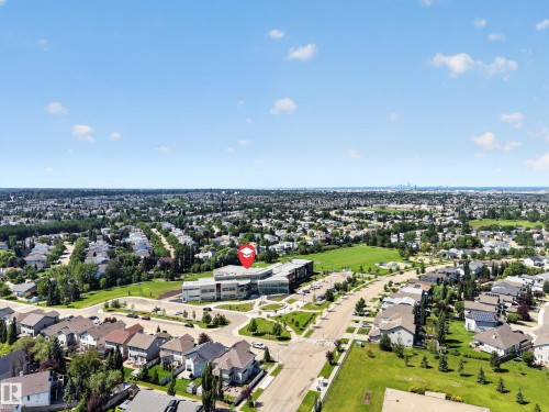 Expansive residential area featuring numerous single-family homes, abundant green spaces, and a prominent institutional building with modern architecture - #7 155 Crocus Cr, Sherwood Park, AB - Outdoor With View
