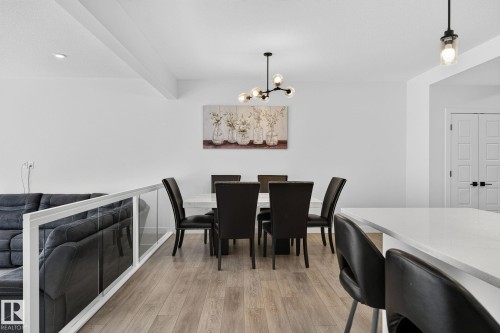 Open concept dining area featuring wood-finish flooring, a contemporary chandelier, and recessed lighting - 23027 96 Avenue Nw, Edmonton, AB - Indoor Photo Showing Dining Room