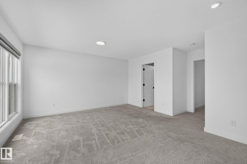 Spacious room featuring neutral carpeting, recessed lighting, white walls, and a large window with white trim - 23027 96 Avenue Nw, Edmonton, AB - Indoor Photo Showing Other Room